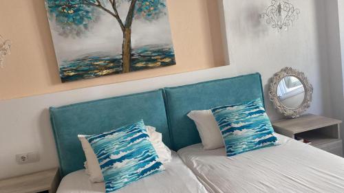 a bedroom with a blue couch with two pillows at INROY SEA VIEW APARTMENTS in Skala Potamias