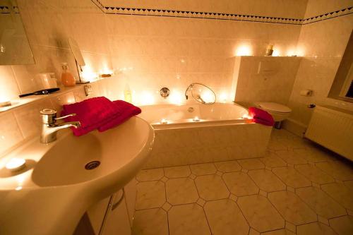 ein Badezimmer mit einem Waschbecken, einer Badewanne und einem WC in der Unterkunft Ferienwohnung am Sandbarg in Jesteburg