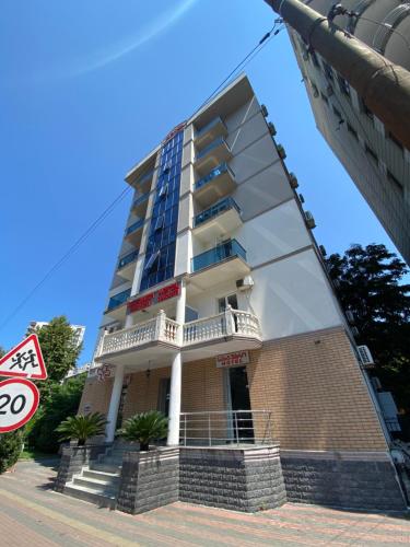 a tall apartment building with a balcony at Hotel Garanti in Batumi