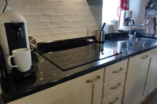 - un comptoir de cuisine avec une cafetière et un évier dans l'établissement Gîtes du Guébriand, à Saint-Lormel