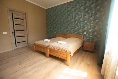 ein Schlafzimmer mit einem Bett mit zwei Handtüchern darauf in der Unterkunft Strawberry in Bordschomi