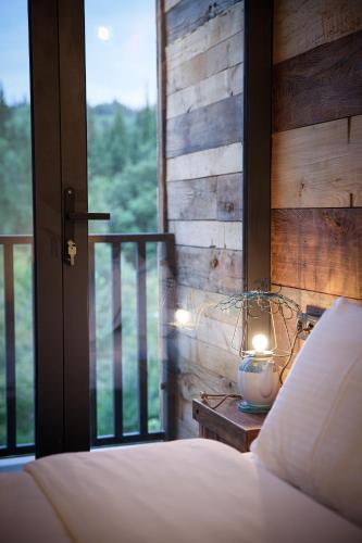 a bedroom with a bed and a window and a lamp at Ethno Sazano Hotel in Sazano
