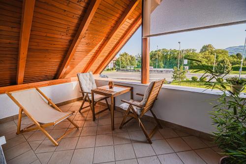 een veranda met 2 stoelen, een tafel en een raam bij Apartments Zora with Terrace near Terme Paradiso in Dobova
