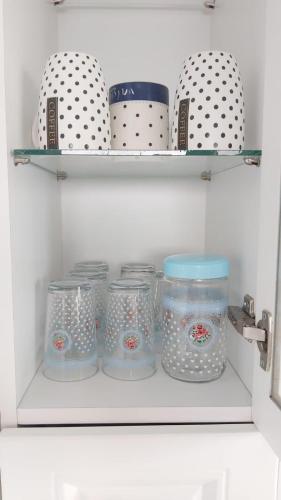 ein Regal mit Gläsern, Platten und Schalen in einem Kühlschrank in der Unterkunft Modern apartment in Batumi