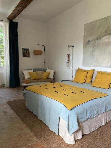 ein Schlafzimmer mit einem großen Bett und einem Sofa in der Unterkunft Le Murier in Vaison-la-Romaine