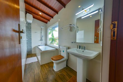 a bathroom with a sink and a toilet and a mirror at The Castle by Don Louis in Kandy