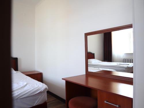 a mirror on a desk in a room with two beds at Jansyn Hotel Restaurant in Karakol