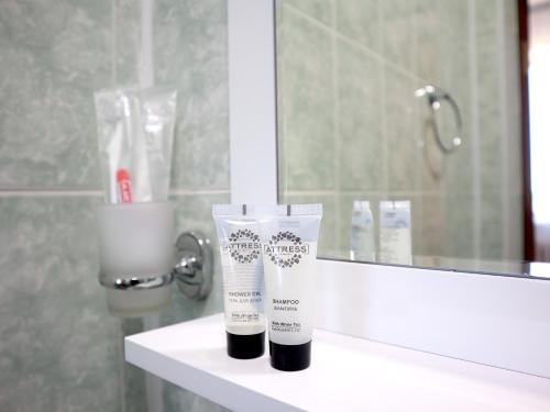 a bathroom counter with a bottle of lotion and a mirror at Jansyn Hotel Restaurant in Karakol