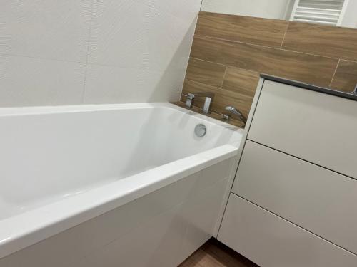 ein Badezimmer mit einer weißen Badewanne neben einem Fenster in der Unterkunft Apartament Mieszczański Klima-ParkigFree2x-Netflix-YouTube in Breslau
