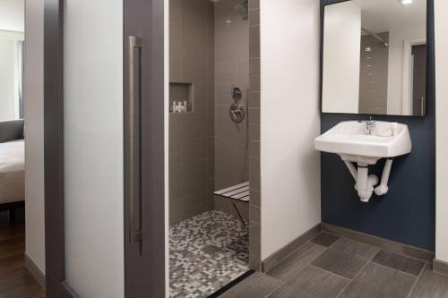 La salle de bains est pourvue d'un lavabo et d'une douche. dans l'établissement The Bidwell Marriott Portland, à Portland