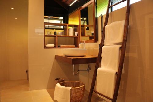 een badkamer met een wastafel en een spiegel bij Le Baan Thai Boutique Villa in Chiang Mai