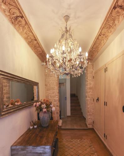 a hallway with a chandelier and a table and stairs at Dorinda Rooms in Alicante