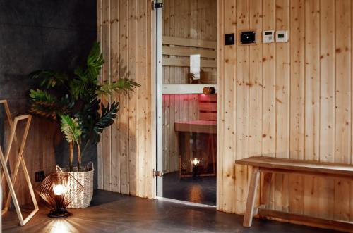 ウストカにあるPomorze Health & Family Resortの木の壁と鉢植えの植物のある部屋