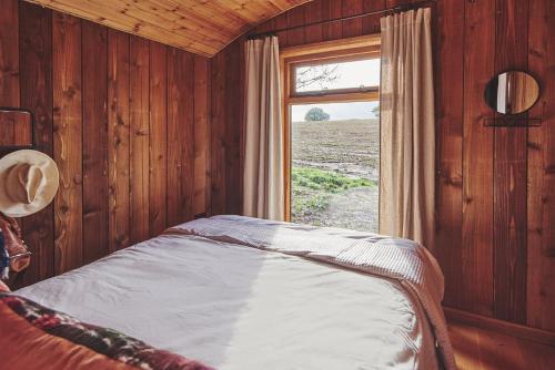 a bedroom with a bed with a window in it at Big Sky Hideaway in Leominster