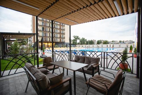 a patio with a table and chairs and a pool at West Inn Georgia in Kutaisi