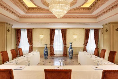 a meeting room with a row of tables and vases at Swiss Diamond Hotel Prishtina in Pristina