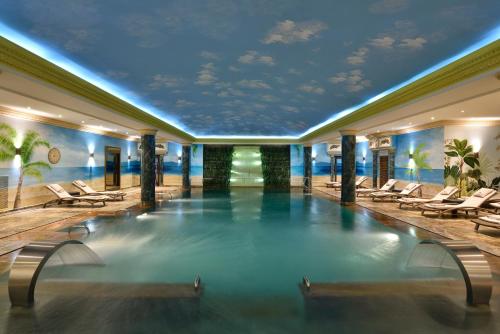 a swimming pool in a hotel with lounge chairs at Swiss Diamond Hotel Prishtina in Pristina
