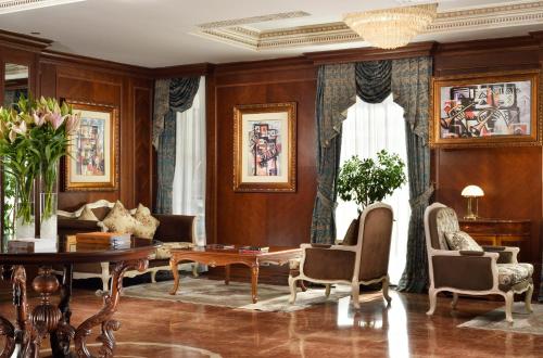 a living room with a table and chairs at Swiss Diamond Hotel Prishtina in Pristina