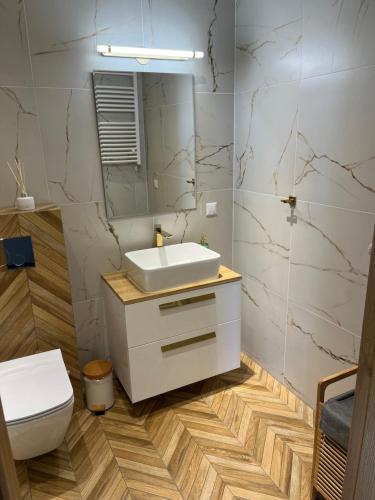 y baño con lavabo blanco y aseo. en Apartamenty Ustronie Morskie 31B3, en Ustronie Morskie