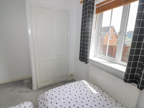 a bedroom with a bed and a window at 12 Clos Yr Wylan in Barry