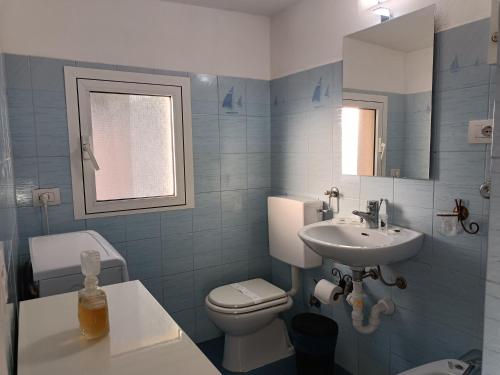 bagno blu con servizi igienici e lavandino di Casetta Mami a Camogli
