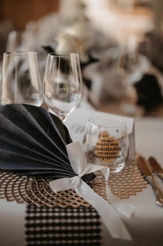 a table with two wine glasses and a bow on it at Wohlfühlhotel Innertalerhof in Gerlos