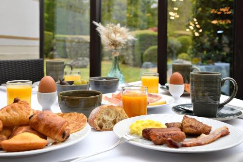 a table topped with plates of breakfast foods and eggs at Château de Pizay in Belleville-sur-Saône