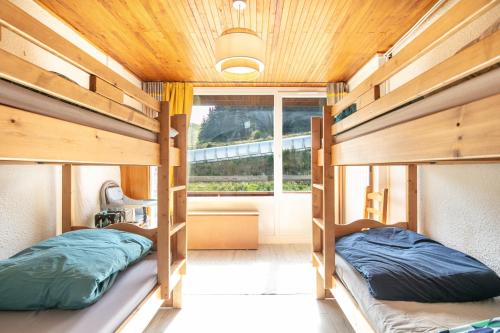 two bunk beds in a room with a window at Le Flocon - Chamrousse 1750 - Sur les pistes in Chamrousse