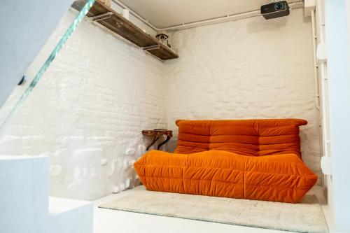 an orange couch sits in the corner of a room at Casa Castelvecchio in Savignano sul Rubicone