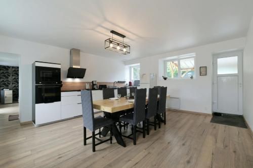 une cuisine et une salle à manger avec une table et des chaises dans l'établissement Au 2 ailes - Charmante maison pour 7, à Picauville
