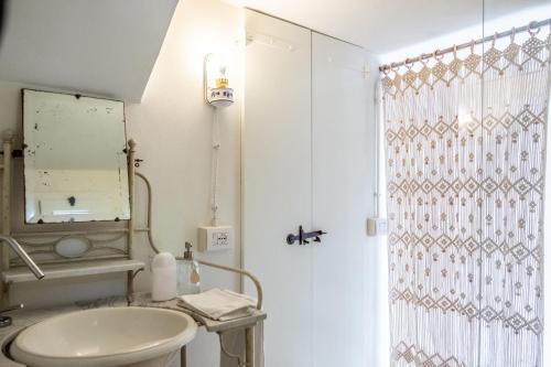 a white bathroom with a sink and a mirror at Casa Castelvecchio in Savignano sul Rubicone