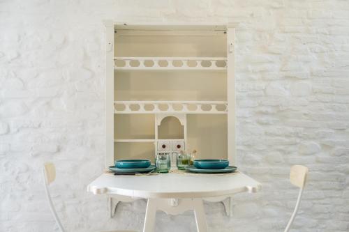 una mesa blanca con cuencos azules en una habitación en Casa Castelvecchio en Savignano sul Rubicone