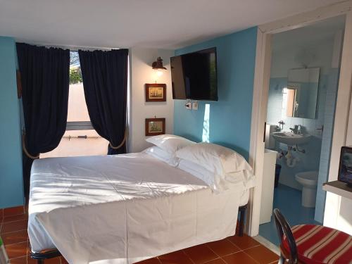 a bedroom with a white bed and a bathroom at Casetta Mami in Camogli