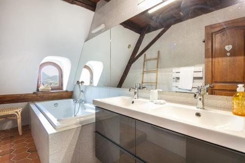 La salle de bains est pourvue de 2 lavabos et d'une baignoire. dans l'établissement Les Tourelles - Duplex au Château d'Uriage, à Saint-Martin-dʼUriage