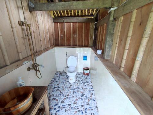 a bathroom with a toilet and a sink and a tub at Lũng Mười Homestay in Nà Giảo
