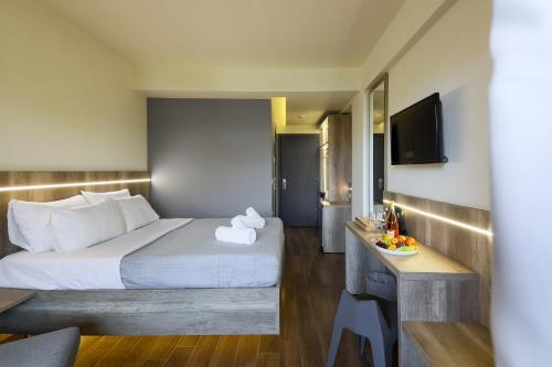 a hotel room with a bed and a television at Hotel Yakinthos in Paralia Katerinis