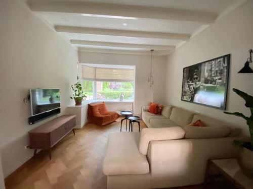 a living room with a couch and a tv at Parkzicht in Leeuwarden