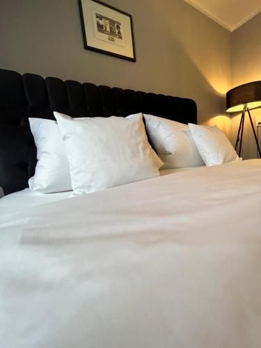 a bed with white sheets and pillows in a room at Boutique Appartement in Torgau