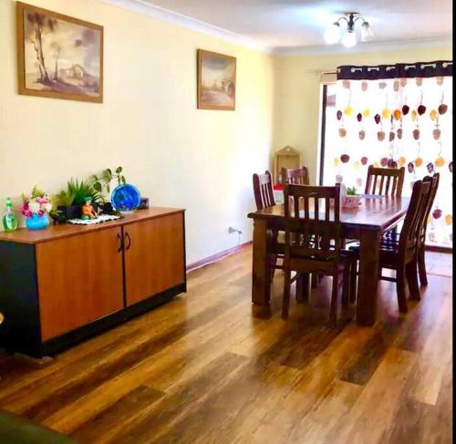 ein Wohnzimmer mit einem Esstisch, einem Tisch und Stühlen in der Unterkunft Diggers Dealers Accommodation in Kalgoorlie