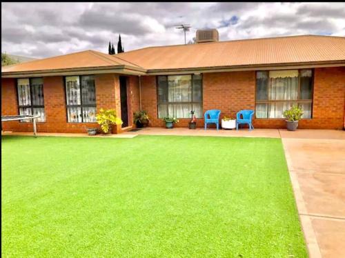 a brick house with a lawn in front of it at Diggers Dealers Accommodation in Kalgoorlie