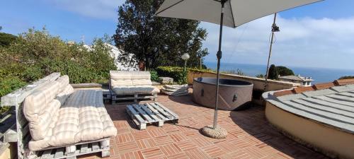 a patio with two lounge chairs and an umbrella at Villa Quadrifoglio in Arenzano
