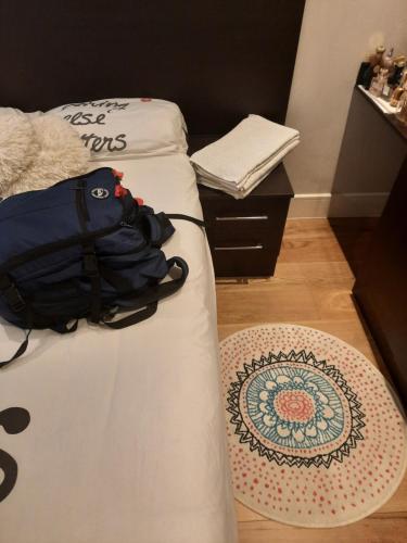 Una cama con una mochila y una alfombra en el suelo en Bitcoin Adorabile suite nel cuore del magnifico Chiswick en Londres