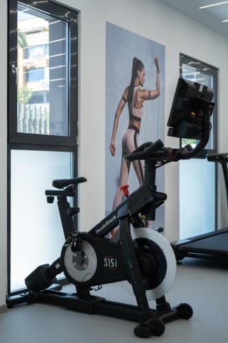 a woman running on a treadmill in a gym at The Edge - Luxury Residences in Athens