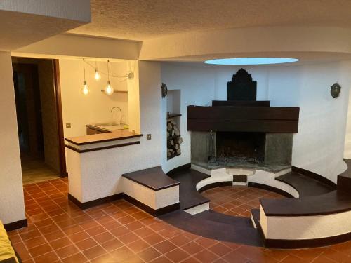 a living room with a fireplace and a kitchen at Villa Quadrifoglio in Arenzano
