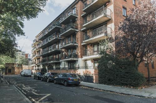 a brick apartment building with cars parked in front of it at Stylish Central London Flat with Sun Terrace in London