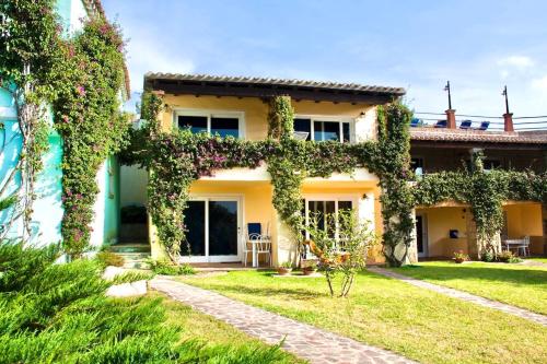 a house covered in ivy in a yard at ISA-Residence with swimming-pool in Porto Rotondo at only 500 m from the beach in Porto Rotondo