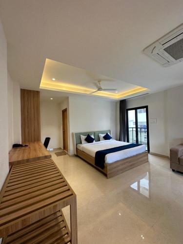 a large bedroom with a bed and a couch at Western Suites HiTech City in Hyderabad