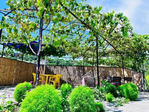 un jardín con sillas, un árbol y una valla en Hotel Sunny, en Akhaltsikhe