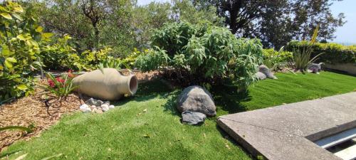 a garden with rocks in the grass and a yard at Villa Quadrifoglio in Arenzano