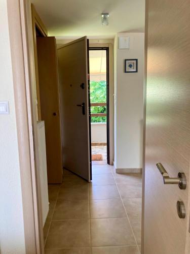 a hallway with a door open to a room with a tile floor at Aestas in Neos Marmaras